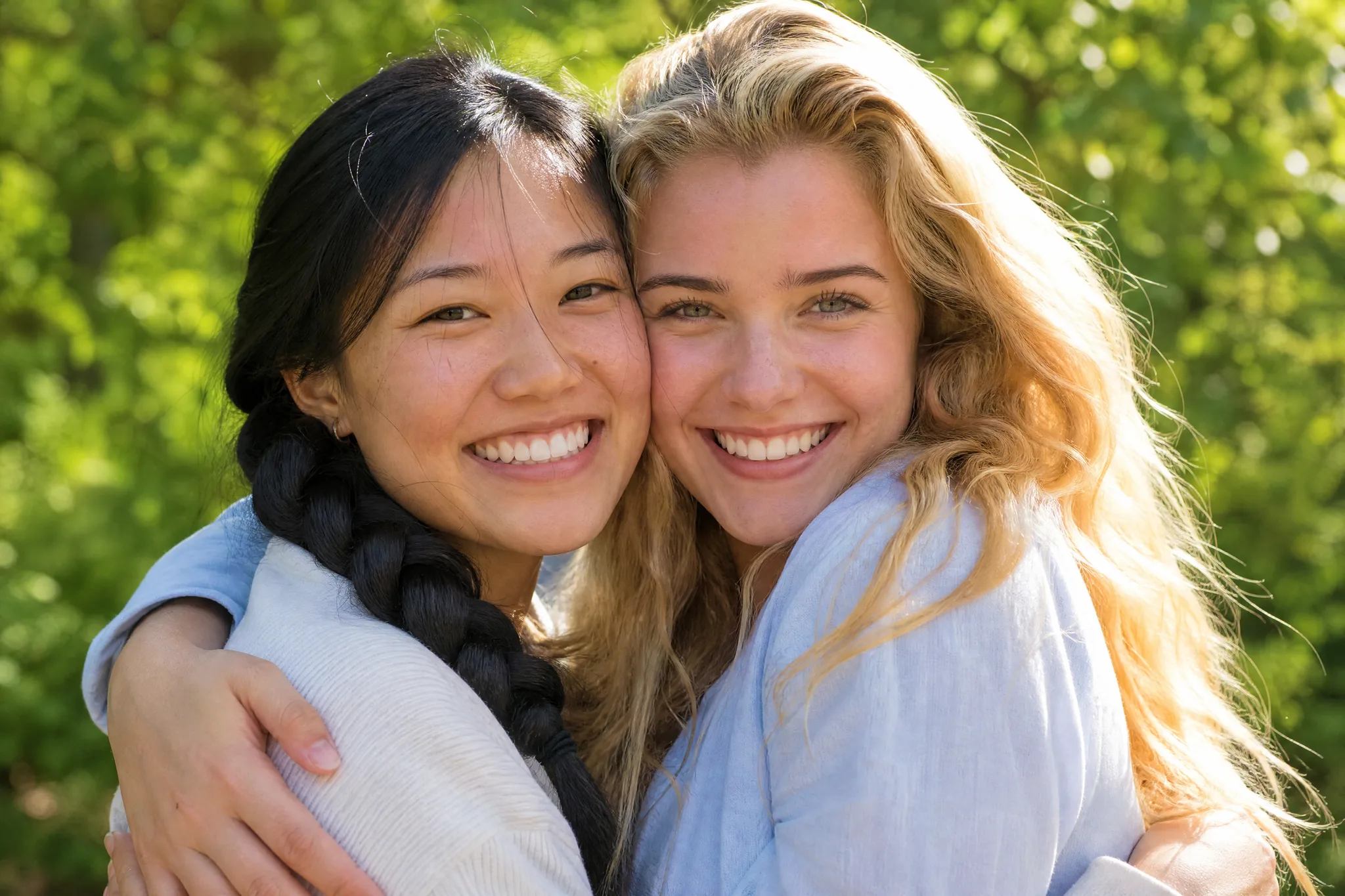 AI Hugging Video: Familiar Faces Two young friends smiling cheek to cheek mid-hug in bright afternoon sun