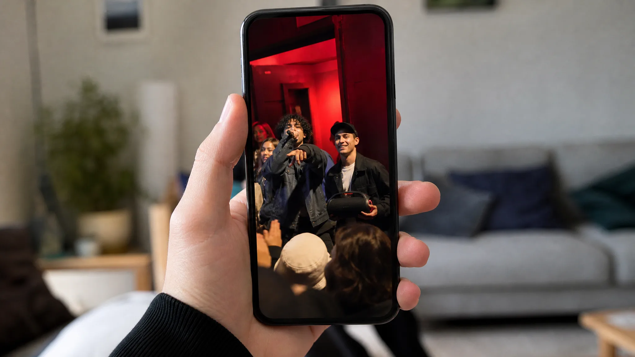 Bulin 47 AI Video Maker: A Vertical Clip Hand holding a phone that plays a vertical clip of the entrance freestyle, with a softly blurred room behind